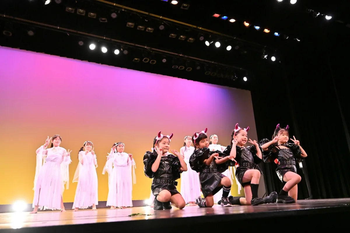 白と黒の衣装で決めポーズを取る出演者